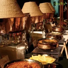 A rustic yet elegant buffet setup featuring traditional copper and brass serving dishes. This style is perfect for weddings with a classic or heritage theme, adding a touch of old world charm to the dining experience.