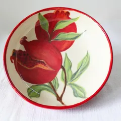 An overhead view of the 'Pomegranate Bowl,' showing the complete hand-painted artwork. The vibrant red rim frames the design beautifully, making it a centerpiece for any table.