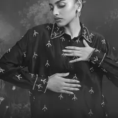 A black and white close-up of our embellished shirt, focusing on the texture and craftsmanship of the hand-sewn details.