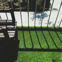 Even a small balcony can become a green escape. Here, the artificial turf adds a touch of nature and comfort, creating a pleasant space to sit and enjoy the outdoors. The shadows from the railing add a nice graphic element.