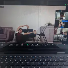 This is what our online classes look like. Even from your own home, you get detailed guidance. Here, a student uses a chair to deepen her hip opening pose, showing that a dedicated practice is possible anywhere.