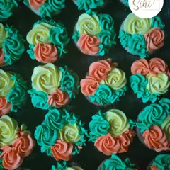 A vibrant and colorful batch of floral buttercream cupcakes. I used a mix of orange, yellow, and teal to create this cheerful and eye-catching design.