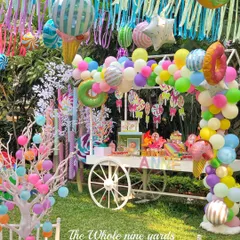 A vibrant Candyland themed birthday party, brought to life with a custom candy cart, a colorful balloon arch, and whimsical decorations. This outdoor setup was designed to be a child's dream, filled with sweets, treats, and playful details like oversized candy props.