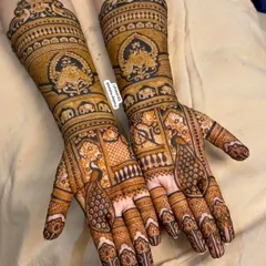 A classic Rajasthani-inspired design with elegant peacocks on the palms and jharokha patterns on the arms. The use of dark and light henna creates a beautiful contrast.