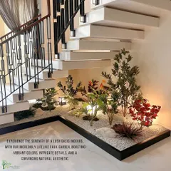 This under-staircase garden demonstrates a different aesthetic, using a variety of colorful faux plants set in a bed of white pebbles. The design incorporates subtle lighting to highlight the textures and create a warm, inviting atmosphere.