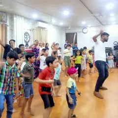 Our kids' fitness classes are all about joyful movement. An instructor leads a group of enthusiastic children in an energetic dance routine during our summer camp, making exercise feel like a party.