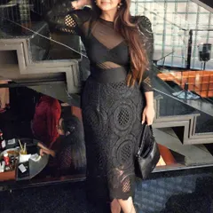 A full-length view of the black lace dress, showcasing its intricate texture and modern silhouette. The right fit and fabric are essential for creating an image of quiet luxury.