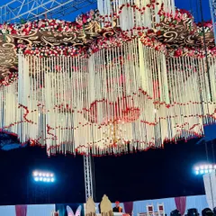 A view of our massive, multi-layered floral chandelier structure suspended over the main stage. The scale of this installation creates a powerful visual impact for a grand wedding.