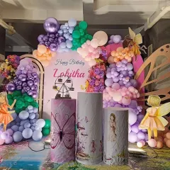 A magical fairy and butterfly garden theme for Lohitha's birthday. This enchanting setup uses a rich palette of purples, pinks, and greens, with fairy cutouts, butterfly wings, and custom-printed pedestals.