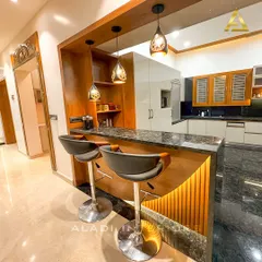 An alternate angle of the breakfast bar, showing the elegant granite countertop and its connection to the home's entryway, demonstrating thoughtful space planning.