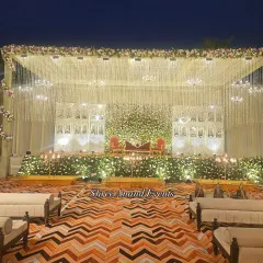 The main stage is the heart of your celebration, and we craft it to perfection. This elegant stage design features a dense wall of white florals, illuminated by hanging crystal tassels and warm ambient lighting.