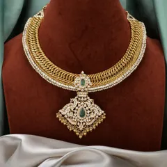 The best of both worlds. This is our stunning gold-plated silver sutarla necklace, featuring an intricate woven design and a grand pendant with emerald and polki-style stones. It gives you the opulent look of gold with the purity of silver.