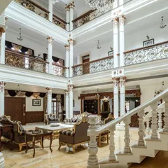 A perspective of the triple-height living space, showing the layers of balconies and corridors overlooking the central hall. The design ensures that the sense of grandeur is felt from every vantage point within the home.