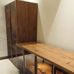 This image shows the side profile of the mandir and bar unit, highlighting the consistent wooden finish and the quality of construction. The slide-and-fold doors of the mandir are neatly tucked away.