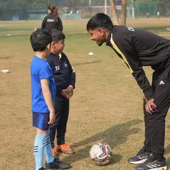 The power of one-on-one attention. A coach connects with young players, providing personalized feedback and encouragement, which is a key part of our training methodology.