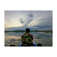 Paddling on the calm water as the sun sets, with beautiful rays breaking through the clouds. This is the perfect way to connect with nature.