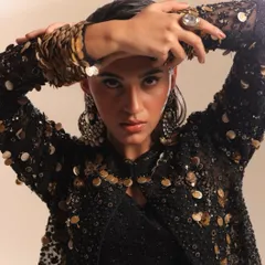 This image is a study in texture and detail. I styled this heavily embellished jacket with coin details and intricate beadwork, using the model's pose to draw attention to the statement ring and cuff bracelets.