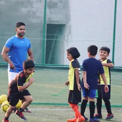 Our coach shares a lighthearted moment with the team during a training session. Building strong, positive relationships is key to our mentorship approach, making learning football fun and engaging.