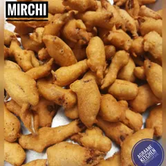 A tray full of hot Mirchi Bajji, a favorite snack for a rainy day. I use fresh green chillies, dip them in a seasoned gram flour batter, and fry them to golden perfection.