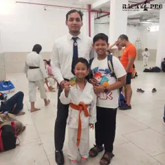 A coach stands with two of our young medalists. Moments like these highlight the strong bond between our instructors and students on their journey to success.