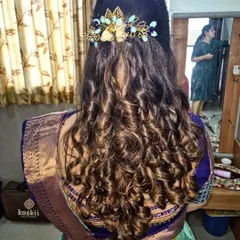 Voluminous curls for a party look. I used different techniques to create texture and bounce, and the style is completed with a stylish gold and blue hair accessory.