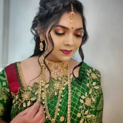 A stunning reception or sangeet look featuring a bronze smokey eye and braided hairstyle. This demonstrates the versatility our students gain, allowing them to cater to all wedding-related events.