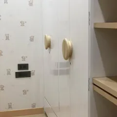 A close-up of the custom wooden handles on the white wardrobe. These small, thoughtful details are what make a piece of furniture special and safe for a child's room.