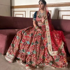 I love the rich patchwork on this red bridal lehenga. It combines different fabrics and embroidery styles, making it a unique and artistic choice for your wedding day.