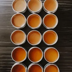 A freshly poured batch of my 'Patalah' lip balm. You can see the beautiful, smooth surface as it sets in the recyclable metal tins. This balm is perfect for healing winter skin and chapped lips.