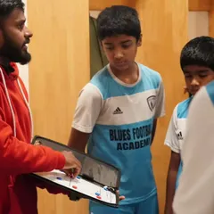 It all starts with a plan. Our licensed coach uses a tactics board to explain positional play to our youth team before a match. We focus on developing intelligent players who understand the game on a deeper level.