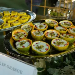 Our "Orange in Orange" dessert is a modern fusion sweet that is as delicious as it is beautiful. A creamy orange-flavored dessert is served inside a hollowed orange peel, topped with pistachios and pomegranate.