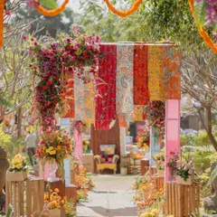 The entrance to our contemporary Rajasthani Mela. A floral archway and hanging printed fabrics framed the view, inviting guests into a world of vibrant celebration.