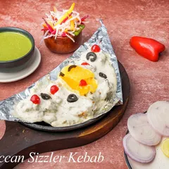 This is our Moroccan Sizzler Kebab. Tender kebabs are served on a sizzling platter, topped with our creamy Moroccan sauce, olives, and cherries for a unique sweet and savoury flavour combination.