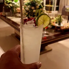 A refreshing gin-based cocktail served in a highball glass. Garnished with dried rose petals and a fresh lime wheel, this drink is a perfect example of our commitment to quality and presentation for any private event.