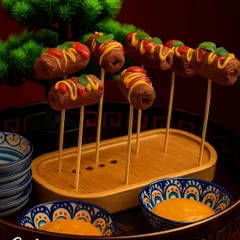 Presentation is key to our service. Here, succulent kebabs are artfully arranged on skewers and drizzled with sauces, transforming a simple dish into a visually stunning appetizer that is ready to be served.