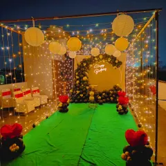 A wide shot of the terrace decoration, showing the seating area in the background. This setup is perfect for hosting a small, private celebration under the stars.