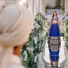The bride's entry is a breathtaking moment. Here, Shaan, in a stunning blue lehenga, walks towards her groom Shubham on a mirrored aisle in Istanbul, a truly cinematic and unforgettable scene.