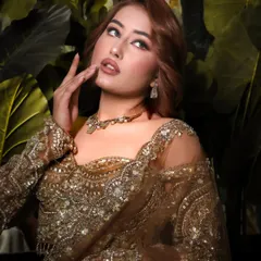 A dramatic and glamorous festive look. The client's hair is styled with soft, voluminous waves that complement her stunning makeup and intricately embroidered outfit.