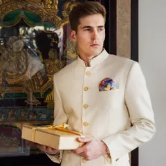 A guest at a wedding or festive event, dressed in a classic bandhgala, holds one of our gift boxes. Our gifts are designed to complement the elegance of such special occasions.