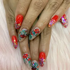 This festive set is perfect for celebrations. It combines a vibrant red base with chunky, multi-colored glitter. The accent nails feature intricate, hand-painted red flowers with green leaves, creating a look that's full of life and color.