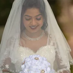 A serene moment behind the veil. The makeup is soft and diffused, creating a dreamy and romantic effect that photographs beautifully.