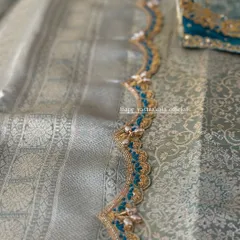 A scalloped saree border with blue and gold embroidery.