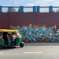 An auto-rickshaw rolling past my "KRYPT" piece in Ahmedabad. The art becomes part of the city's fabric, a backdrop to everyday life.