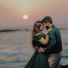 A classic romantic pre-wedding pose against a beautiful sunset. The deep green off-shoulder gown adds a touch of elegance to this beach photoshoot.
