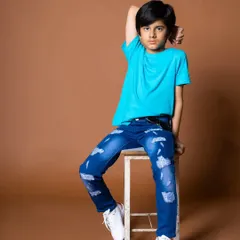 A cool and confident pose for a kids' fashion catalogue. The clean brown background provides a warm alternative to standard white for e-commerce.