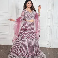 A smiling shot of the full wine-colored lehenga set. The outfit includes a detailed blouse, a voluminous skirt, a matching dupatta, and all the diamond-look jewellery shown.