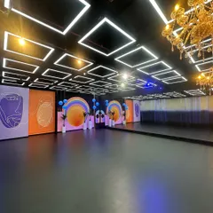 A full view of our main floor, showcasing the large mirrored wall which is perfect for dance rehearsals, alongside our various movable set panels. The combination of the black floor and LED ceiling offers a high-contrast, professional look for any production.