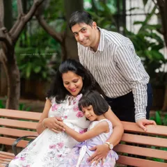 A sweet family photo on a park bench, where the daughter hugs her mother's pregnant belly. These are the moments that show the love of the entire family.