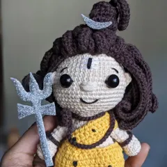 My handmade Lord Shiva doll, held in hand to show its size. It features his Trishula, the crescent moon, and matted hair.