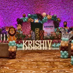 A grand jungle-themed stage for a second birthday party. I used animal print props, character cutouts, marquee letters, and a lush balloon arch to create a vibrant safari look.